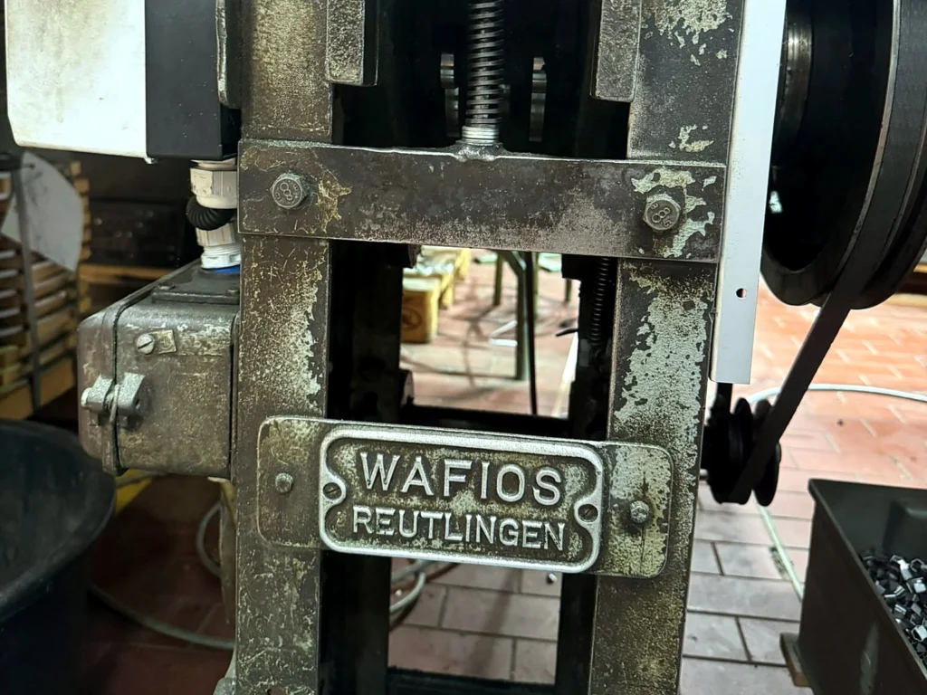 WAFIOS-Presse, an der die Randfedern mit dem Randdraht fixiert werden